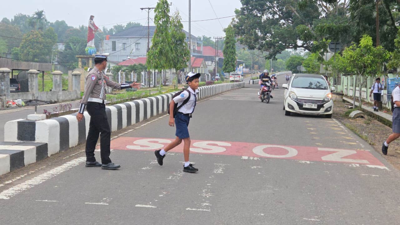 Personil Sat Lantas Lamandau Bantu Menyebrangkan Anak Sekolah