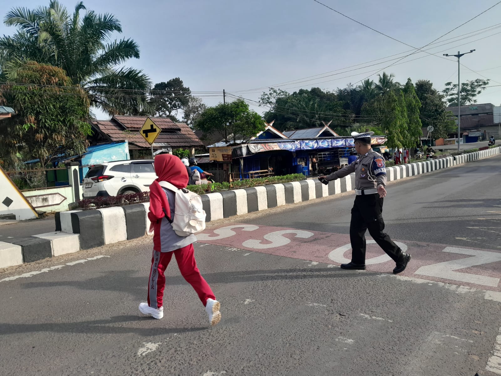 Personil Sat Lantas Lamandau Bantu Menyebrangkan Anak Sekolah